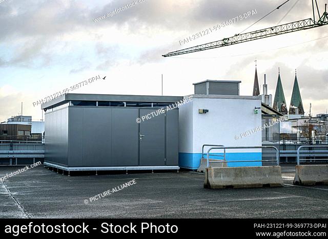 PRODUCTION - 20 December 2023, Bremen: The municipal pigeon house (l) on the Am Brill parking garage. Up to 200 pigeons are to be housed in the house on the top...