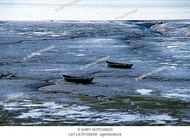 Coast. Cook inlet. Low tide. Bare rock. Two boats beached