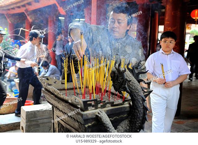 Worshipping by burning incense sticks at House of Ceremonies (Bai Duong), Temple of Literature (Van Mieu), Hanoi, Vietnam