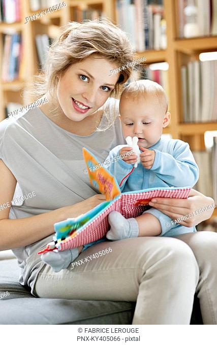 Woman showing a picture book to her daughter