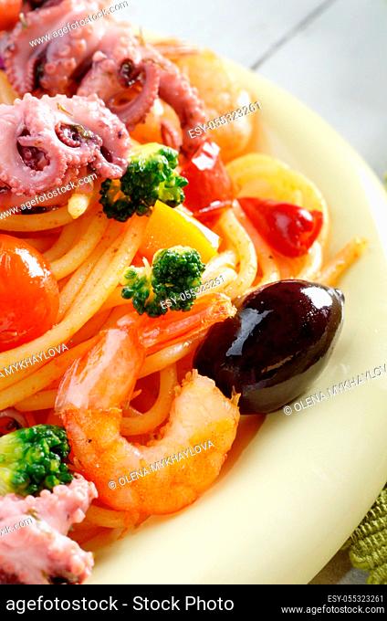 Seafood spaghetti pasta dish with octopus shrimps cherry tomatoes and olives