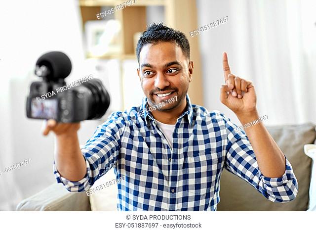 male video blogger with camera blogging at home
