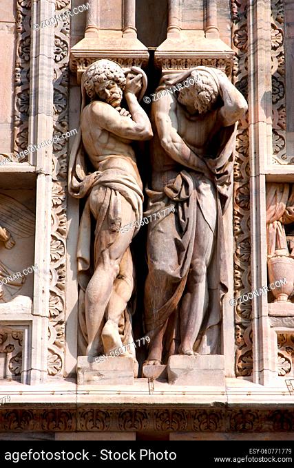 italy two statue of a men in the front of the duomo church in milan