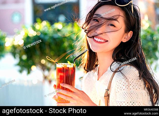 Happy young woman holding a summer drink