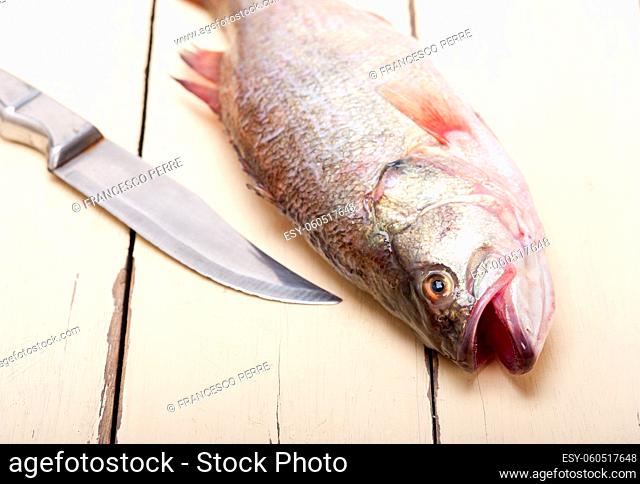 fresh whole raw fish on a wooden table ready to cook