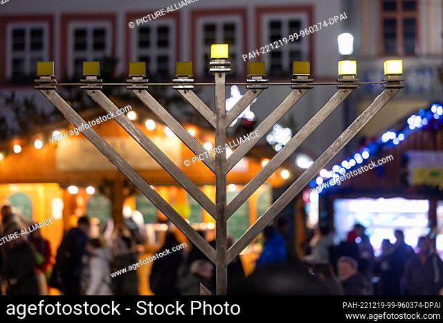 19 December 2022, Thuringia, Erfurt: The second light shines on the Hanukkah candlestick in front of the City Hall at the Fish Market