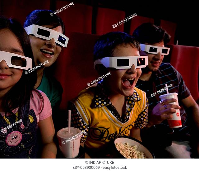 Family watching a movie with 3D glasses