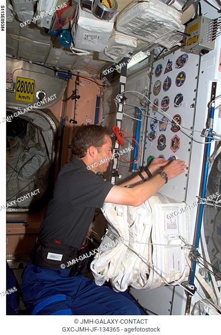 Astronaut James D. Wetherbee, STS-113 mission commander, adds the STS-113 patch to the growing collection of those representing Shuttle crews who have worked on...