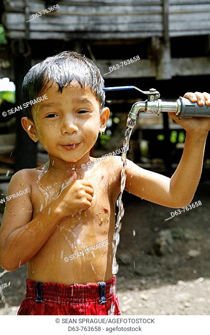 INDONESIA  Boy taking a bath at a CRS provided tap in Paloh village, Pulo Aceh, Aceh  2 years after the Tsunami