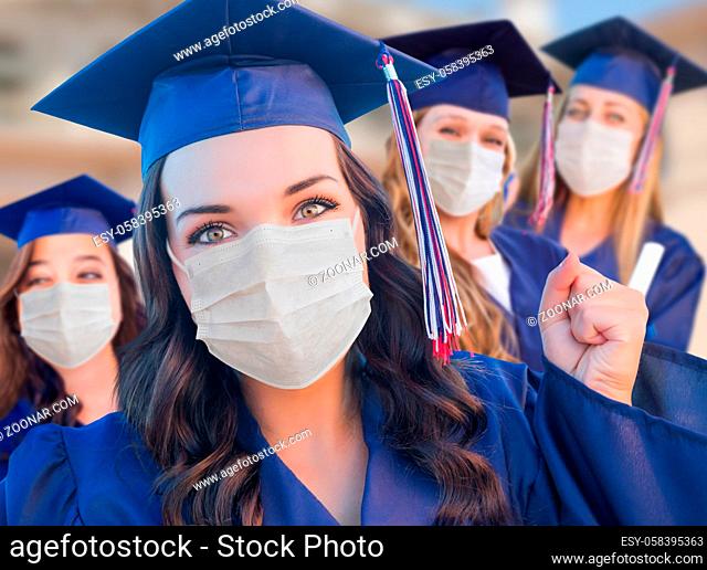 Several Female Graduates in Cap and Gown Wearing Medical Face Masks