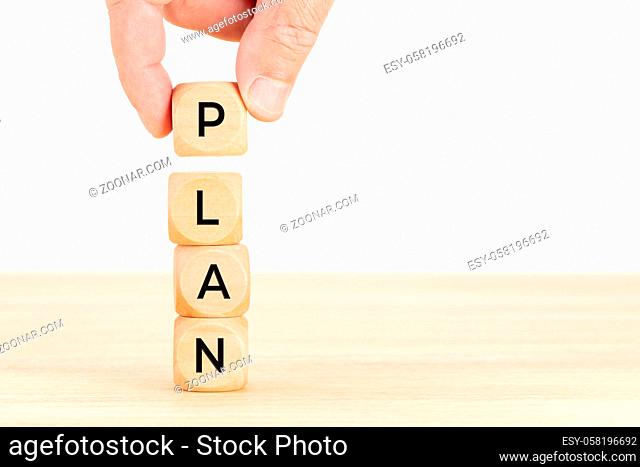 Plan concept. Hand holding a Wooden block with text on table. Copy space