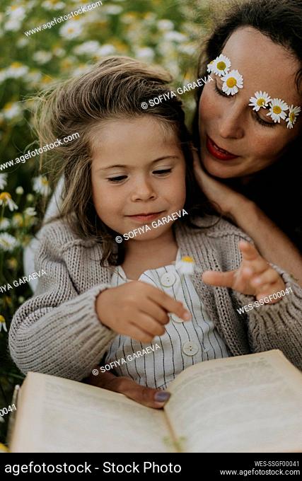 Mother with flowers and book looking at daughter