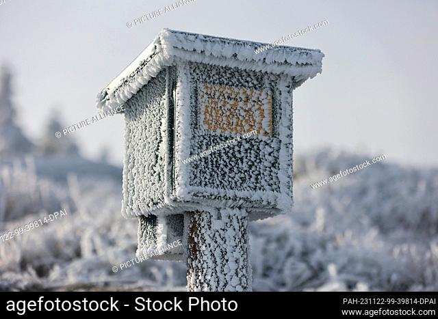 22 November 2023, Saxony-Anhalt, Schierke: Covered in hoarfrost is a stamp box for the Harz hiking pin in the Harz National Park on the Brocken