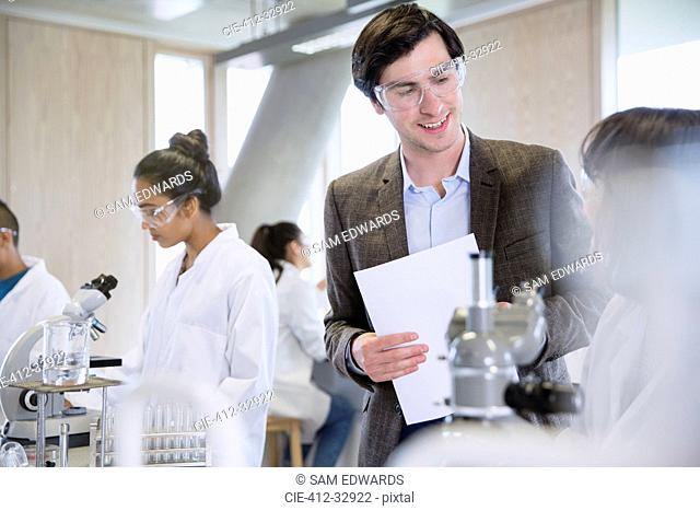 Science professor helping college student in science laboratory classroom