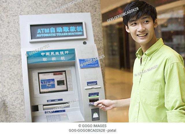 Young man using a cash machine