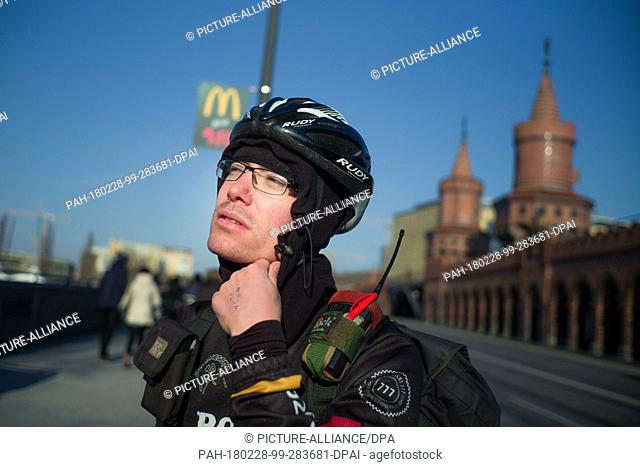 28 February 2018, Germany, Berlin: Bike courier Anselm Holthaus puts on his helmet on the Oberbaum bridge in Kreuzberg. Due to the constant minus temperatures...