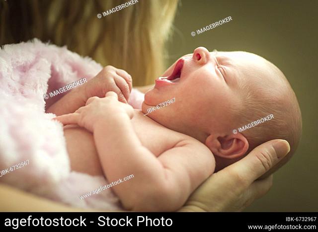 Gentle hands of mother holding her precious newborn baby girl