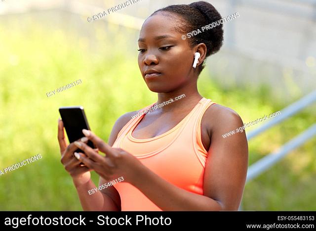 african american woman with earphones and phone