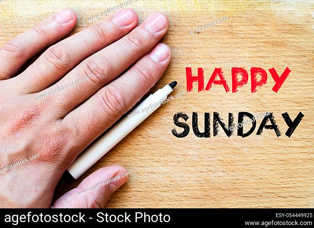 Human hand over wooden background and happy sunday text concept