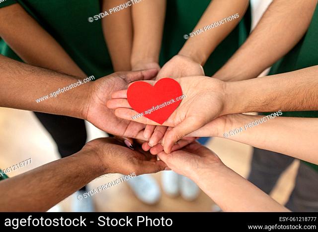 close up of volunteers's hands holding red heart
