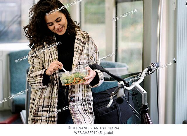 Young woman with bicycle having a lunch on a subway