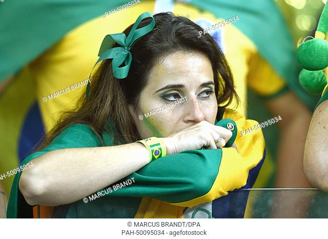 A female Brazilian fan reacts during the FIFA World Cup 2014 semi-final soccer match between Brazil and Germany at Estadio Mineirao in Belo Horizonte, Brazil