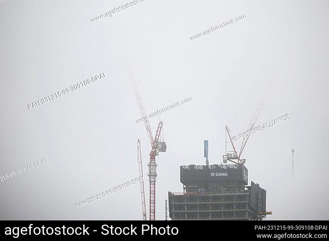 15 December 2023, Hamburg: The cranes over the top of the Elbtower construction site in Hafencity disappear into the fog. At 244