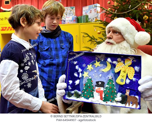 Santa Claus listens to the wish lists of children Leena (9, l-r) from Berlin, Sarah (12) from Prenzlau in Himmelpfort, Germany, 18 December 2015