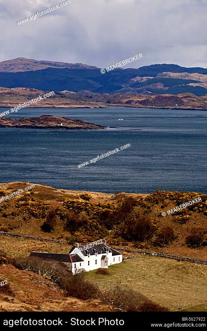 View of coastline and remote farmhouse, former home of George Orwell where he wrote 'Nineteen Eighty-Four' novel, view across Sound of Jura to mainland