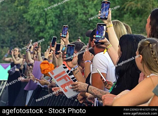PRODUCTION - 02 September 2023, Bavaria, Munich: Visitors and attendees film an artist at the ""Superbloom"" music festival