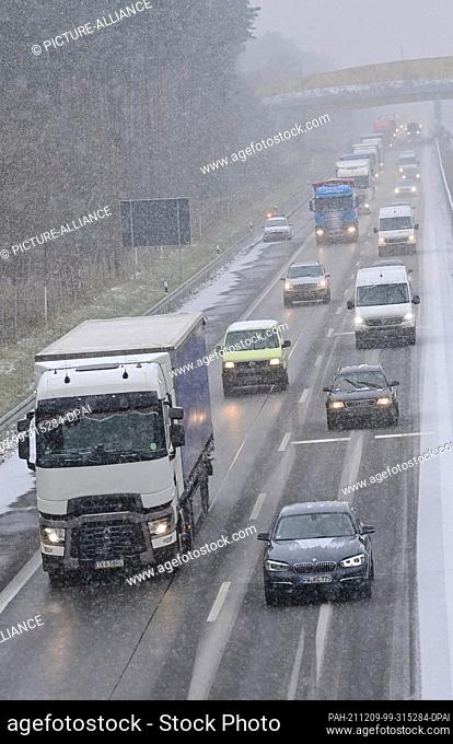 09 December 2021, Brandenburg, Jacobsdorf: Snowfall hinders traffic on the A12 motorway. It has been snowing in large parts of Brandenburg since the morning
