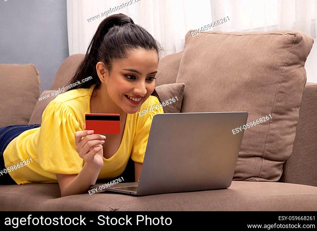 A young woman with laptop and credit card shopping online