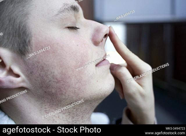 women's finger guiding nose of young man