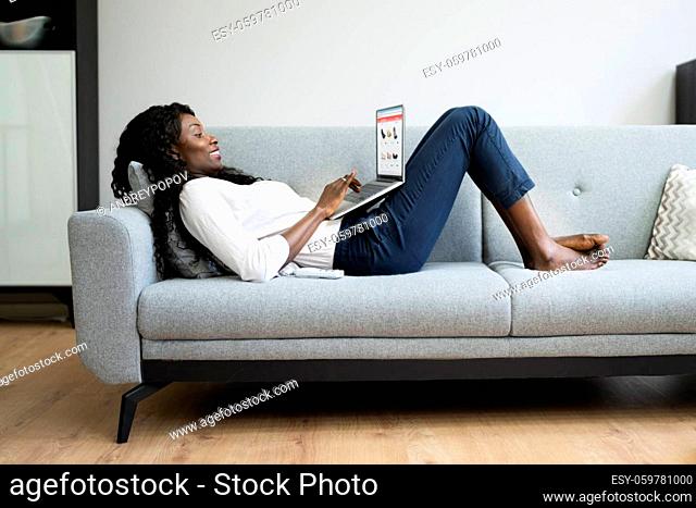 Relaxed Woman Online Shopping On Couch Using Laptop