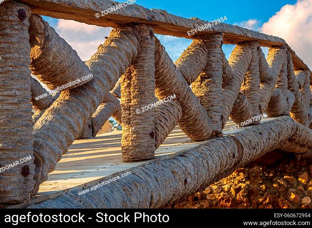 Wooden fence made of palm trunks with partly cloudy sky in sunrise time at Montaza public park in summer time, Alexandria, Egypt
