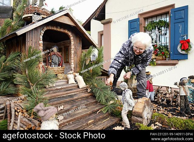 30 November 2023, Rhineland-Palatinate, Bornheim: Ulla Kaub, initiator of the ""Nativity Village"", builds a nativity scene