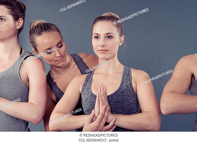 Young women practising yoga, grey background