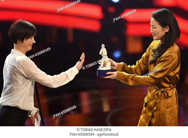 Actress Jule Ronstedt hands director and actress Uisenma Borchu her award during the Bavarian Film Prize 2016 award ceremony in Munich, Germany, 15 January 2016