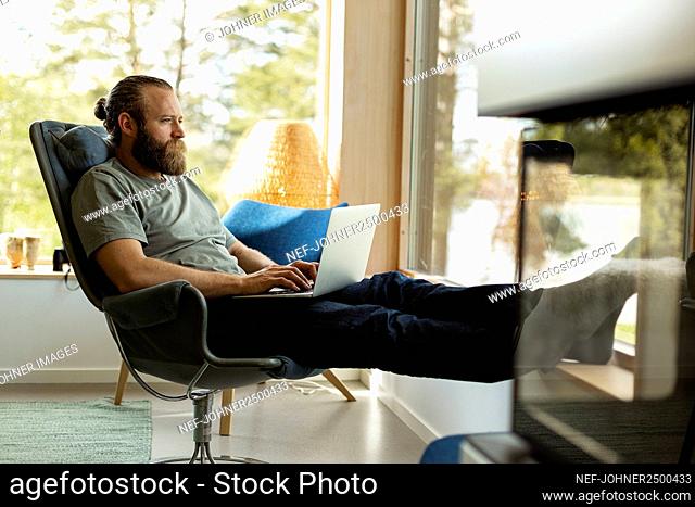 Man sitting on chair and using laptop