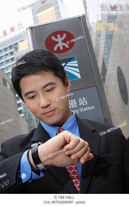 Businessman checking watch outdoors