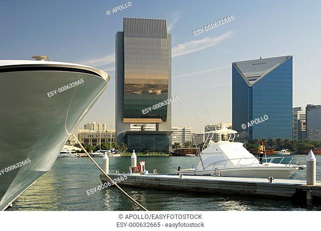 Yachts and modern architecture on the banks of the Dubai Creek, buildings of the National Bank of Dubai, NBD, and the Dubai Chamber of Commerce and Industry