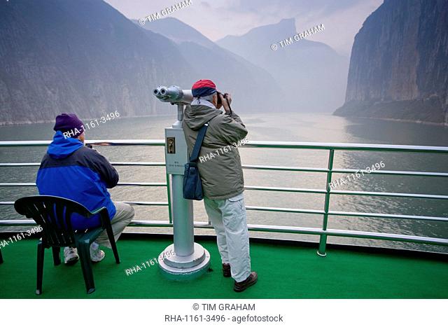Tourists take photographs from the deck of a Victoria Line Cruise Ship, Yangze River, China