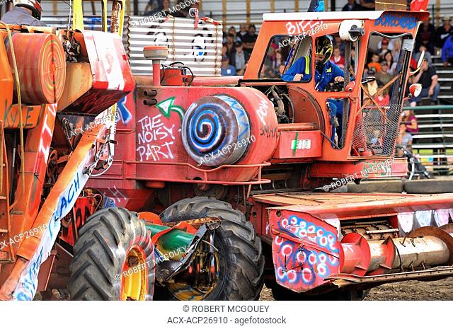 Two combine harvesters do battle in a farm equipment demolition derby in rural Alberta Canada