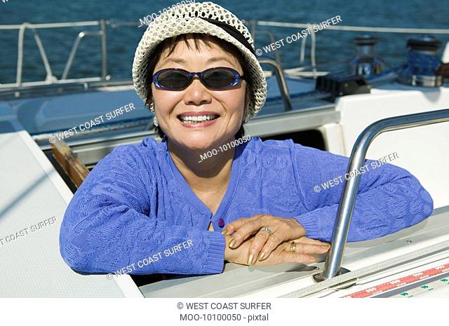Woman wearing sunglasses on sailboat smiling portrait