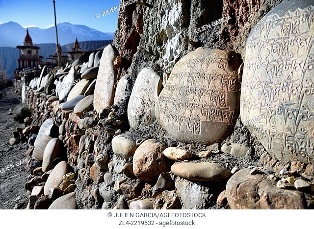 Mani wall (stones inscribed with a buddhist mantra) and stupa (chorten) in the village of Tangge. Nepal, Gandaki, Upper Mustang (near the border with Tibet)
