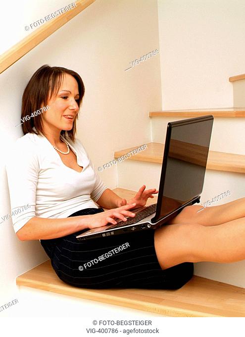 Young business woman sitting on stairs and using laptop. - 09/02/2007