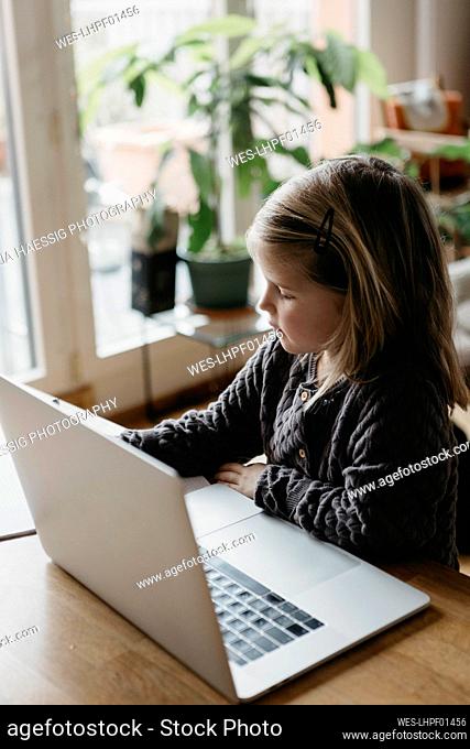 Girl with laptop studying at home