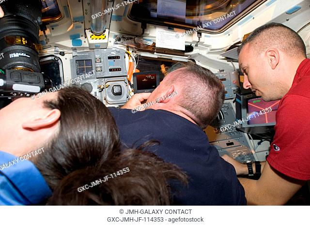 Three members of the STS-129Atlantis crew take some final glances and photographs of the International Space Station during post-undocking activities aboard the...