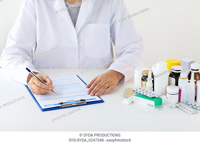 doctor with medicines and clipboard at hospital