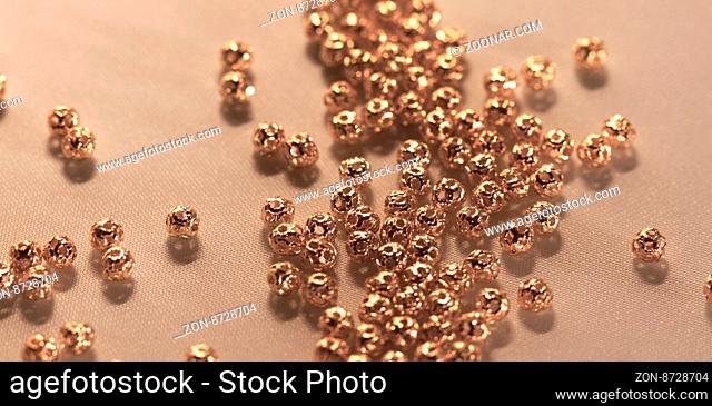 Beautiful golden metal beads closeup on white background